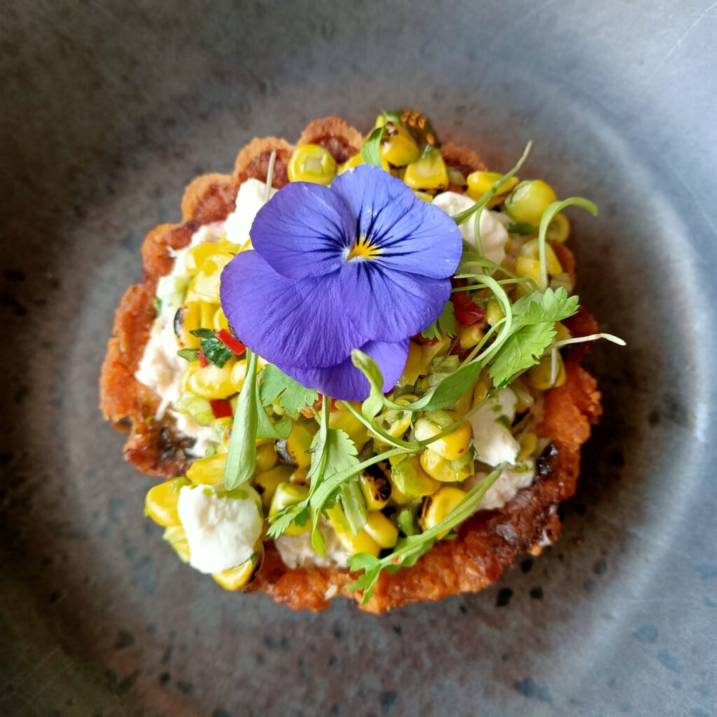 photo of a round tart with a purple flower on top