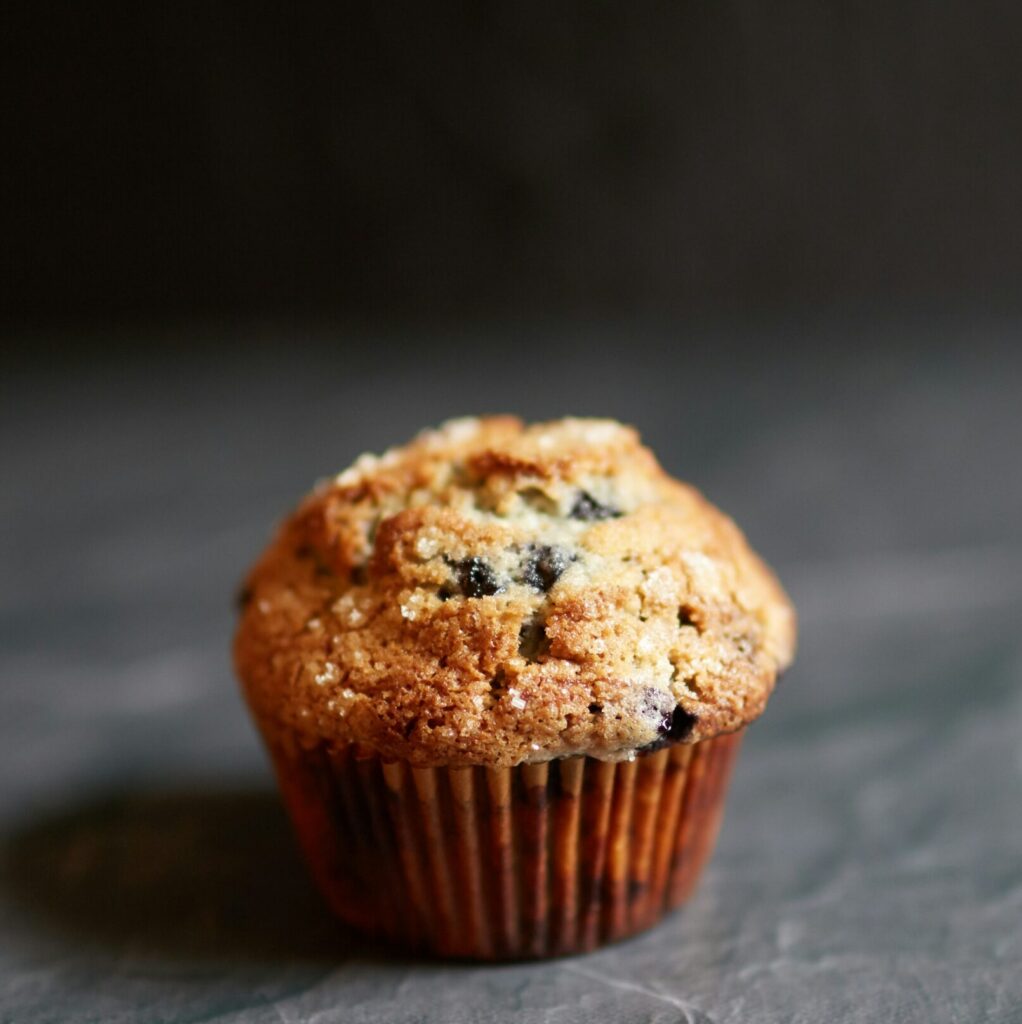 close up photo of a fruit muffin against a dark grey background