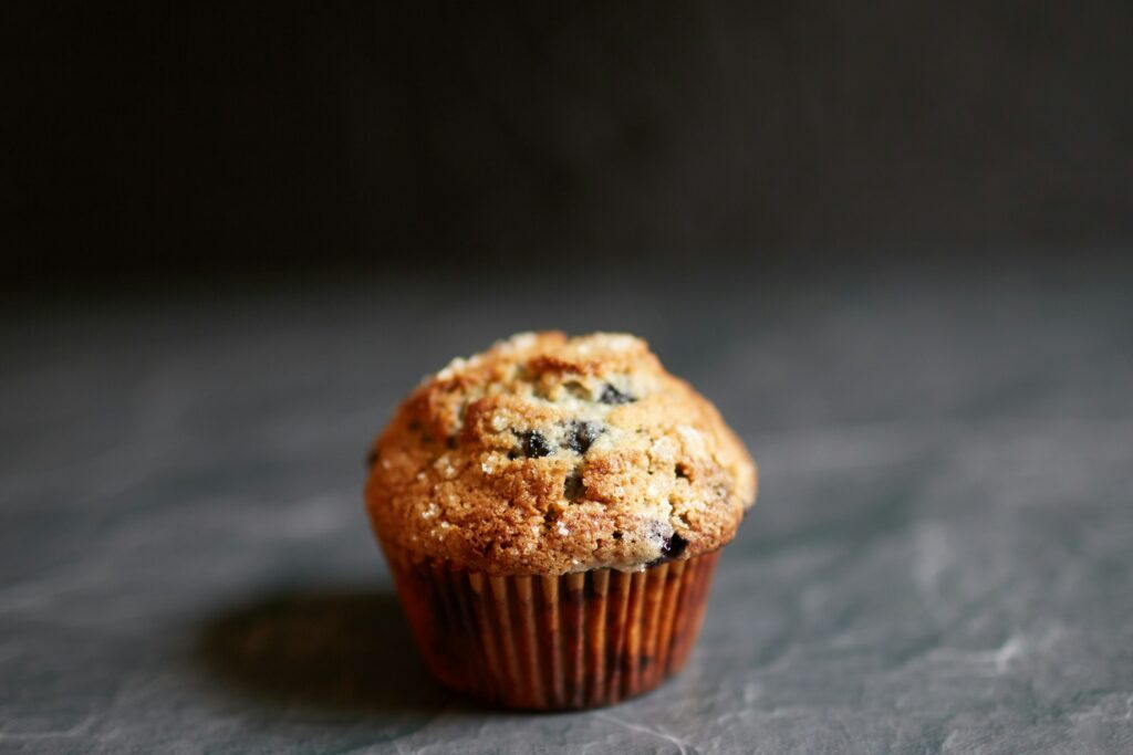 close up photo of a fruit muffin against a dark grey background