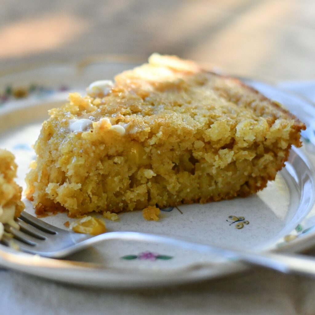 photo of a slice yellow bread cake on a cermaic plate and a fork in front