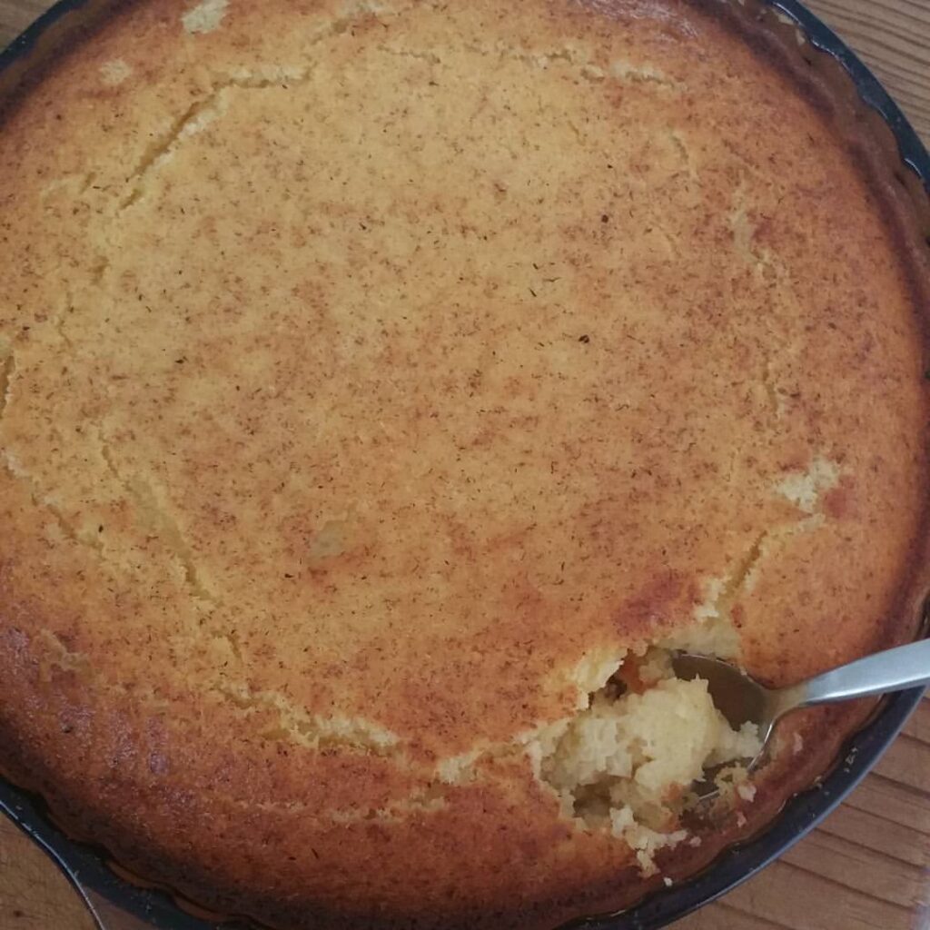 photo of a golden brown baked dessert with a spoon on the right