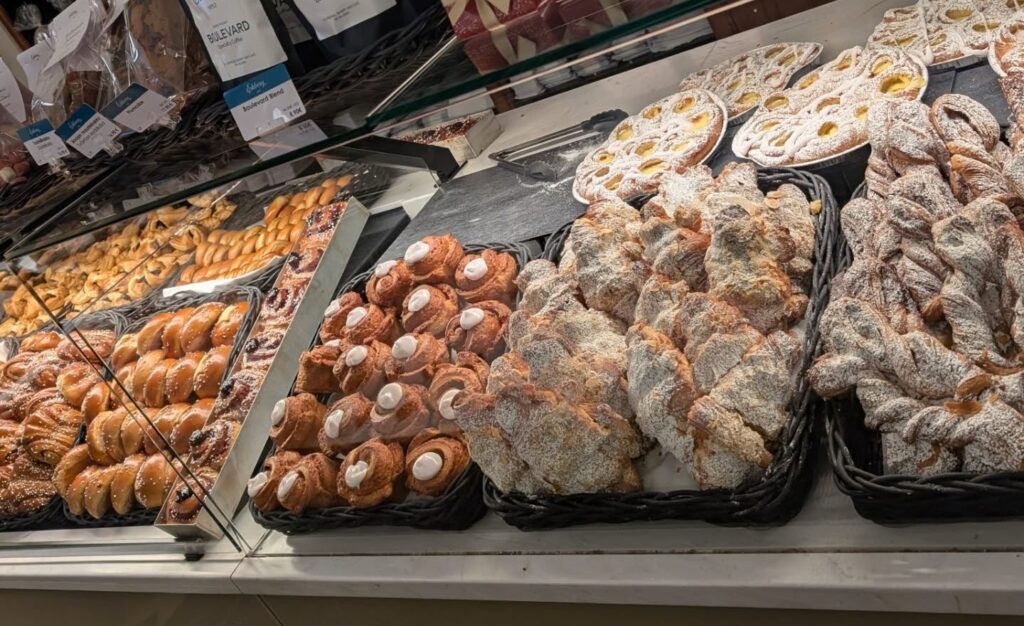 photo of a bakery with lots of croissants and pastries