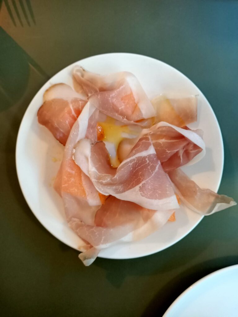 photo of proscuitto and melon on a white plate