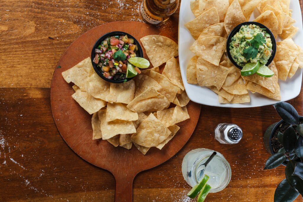 photo of a plate of tortilla chips and bowls of salsa