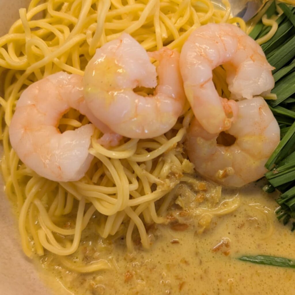 close up of laksa with noodles and prawns