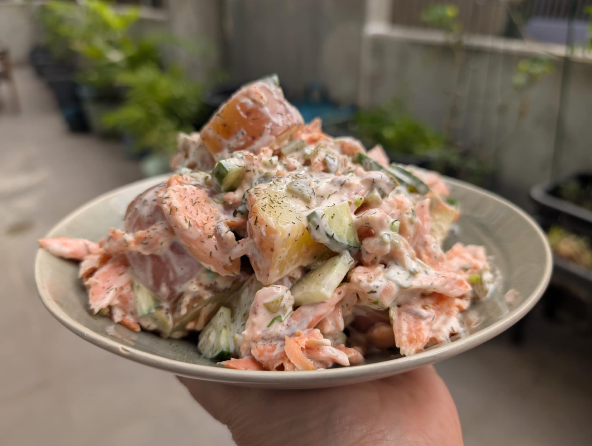photo of a bowl with potato and trout salad covered in mayonnaise