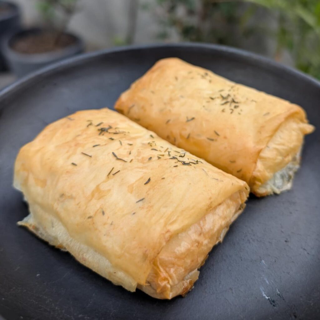 photo of a square pastry on a black plate
