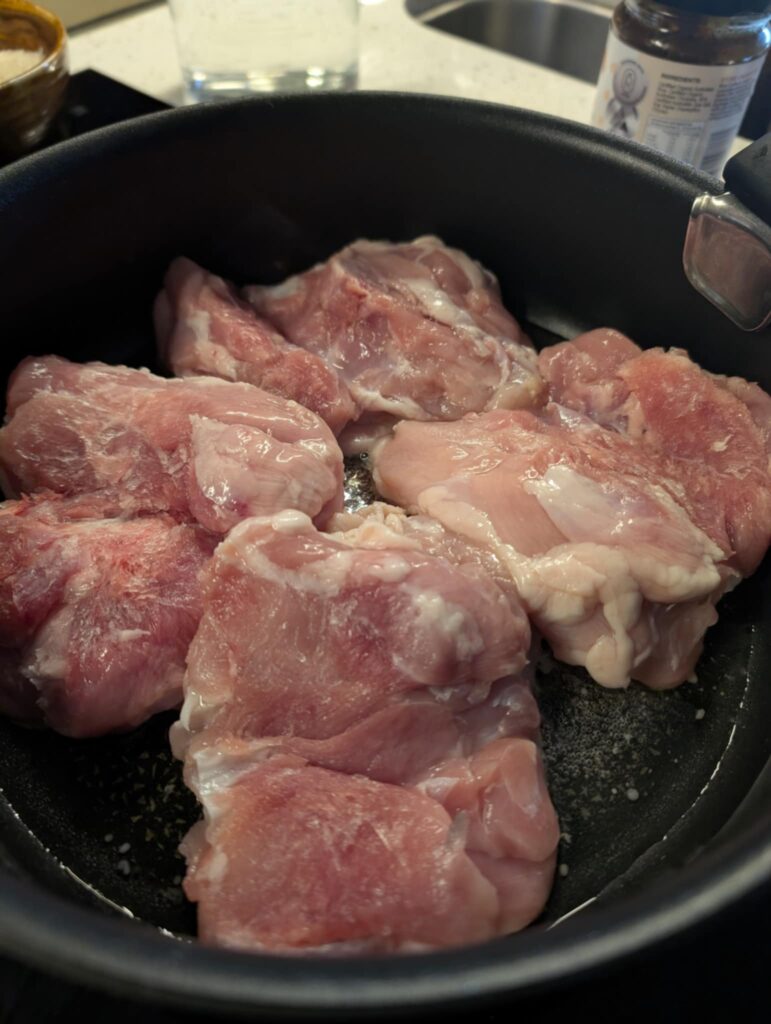 raw chicken in a black pan