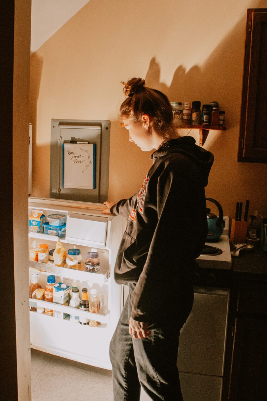 photo of a woman staring at an open fridge