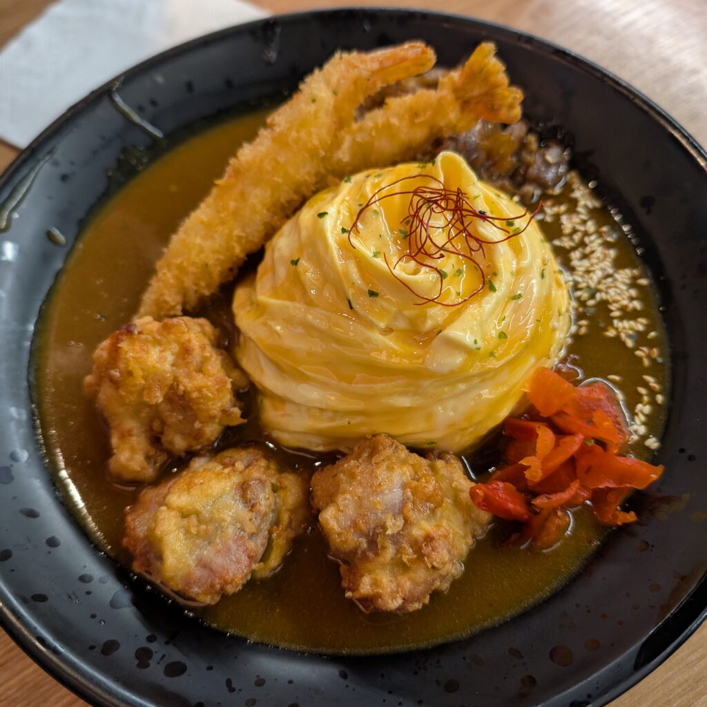 photo of swirled egg omelette with curry sauce in a black bowl