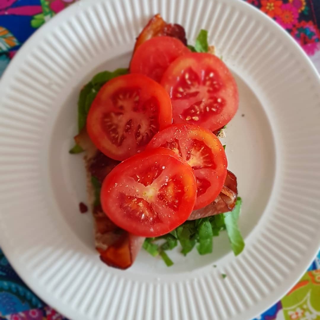 photo of slices of tomato and other food on a white plate