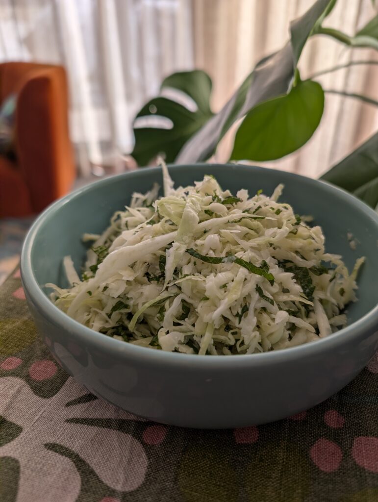 photo of a pale green bowl with a shredded salad