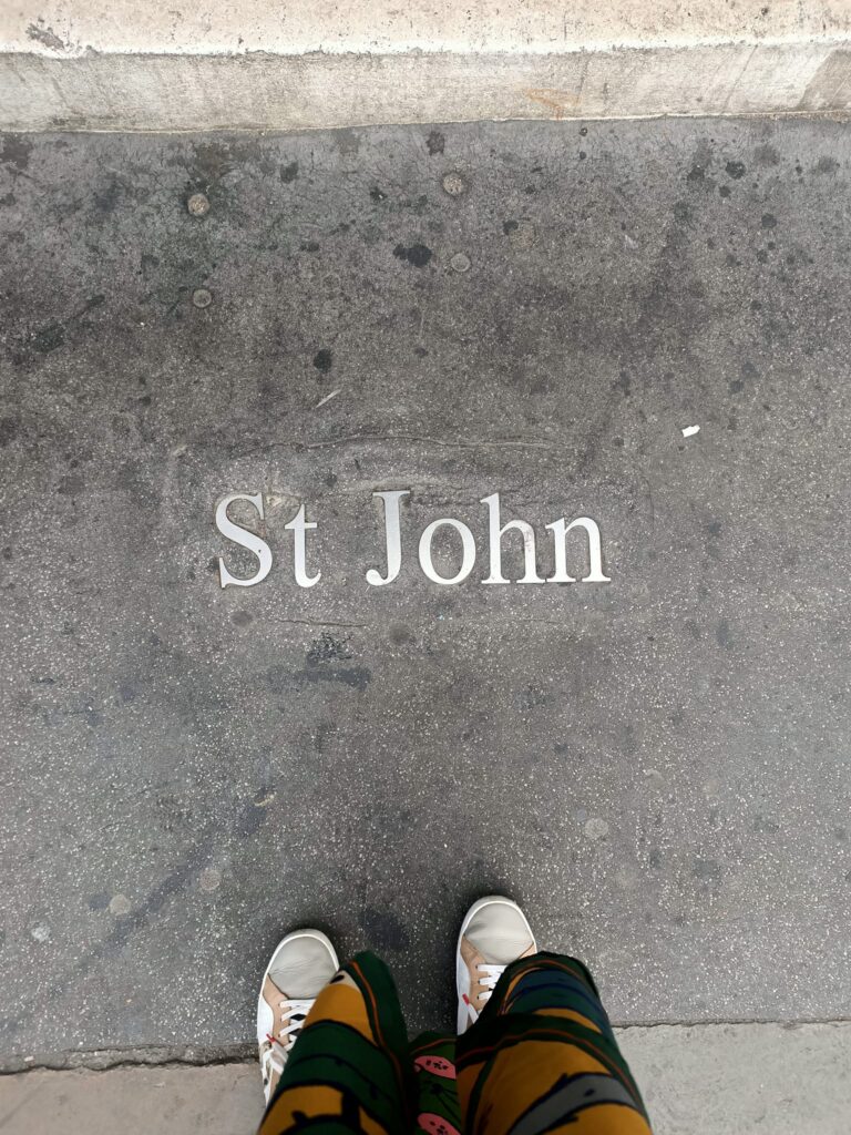 photo of feet standing on the footpath with text St John in the concrete