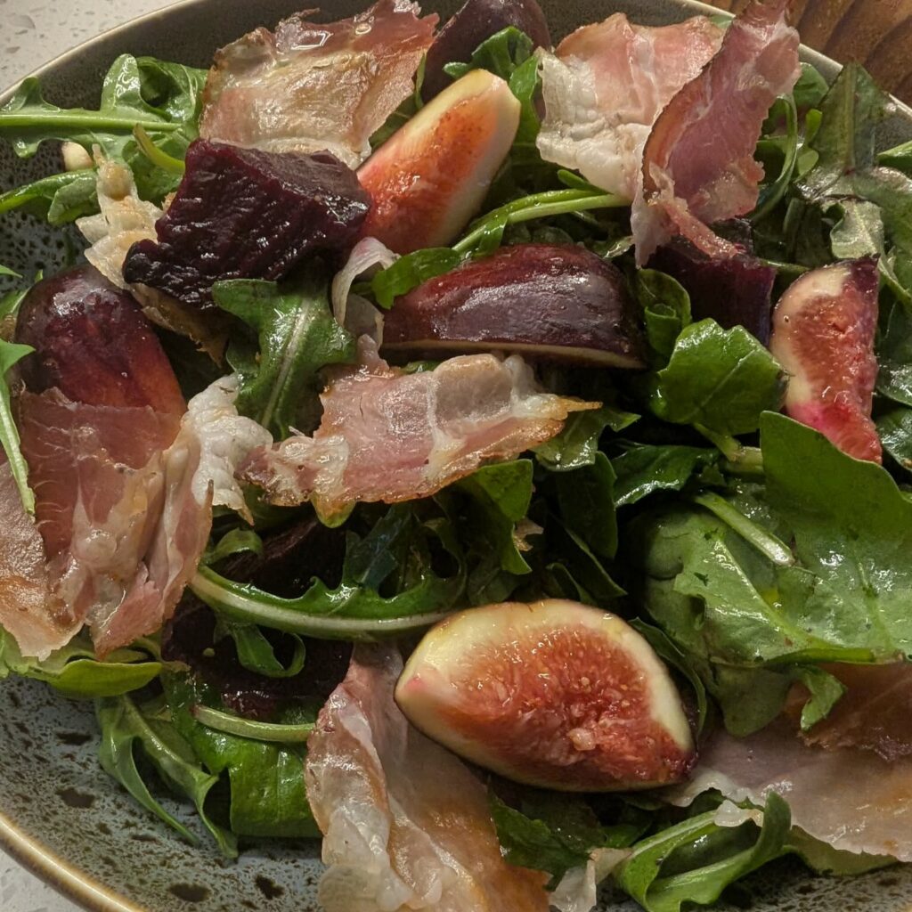 close up photo of a salad with figs, pancetta, rocket and beetroot